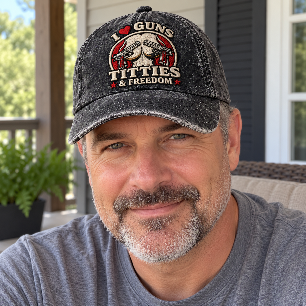 An adult man wearing the washed-black graphic cap with a plain casual shirt outdoors