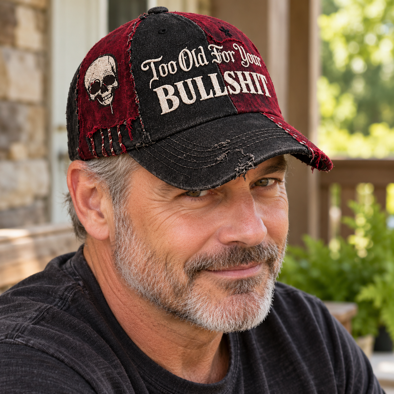 An adult man wearing the black and burgundy Too Old For Your BULLSHIT cap in a casual outdoor setting
