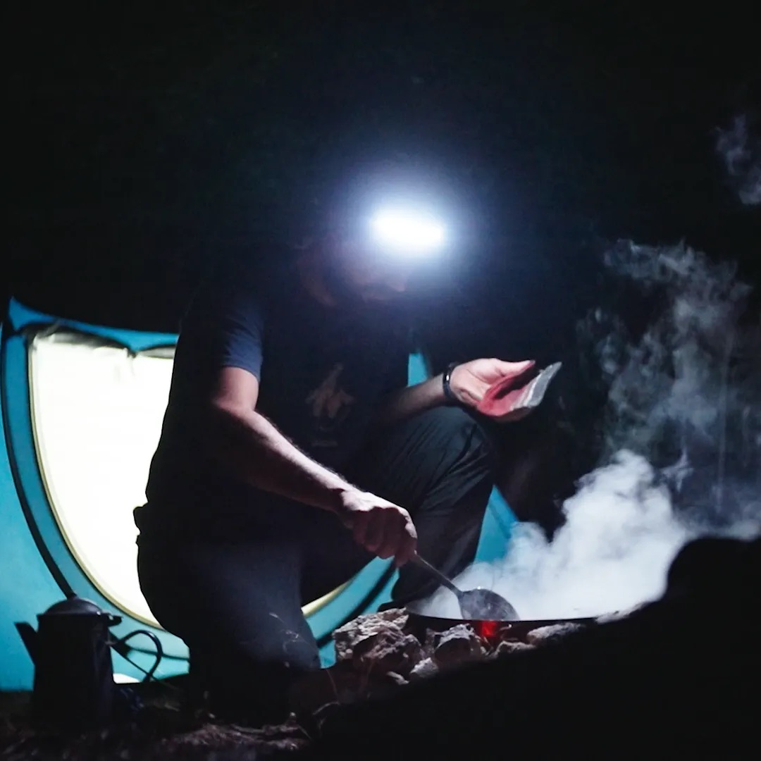 JordiLight used as a headlamp while cooking at a campsite at night