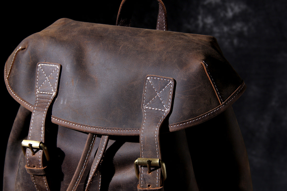 leather day backpack with gold-tone brass hardware and metallic buckle