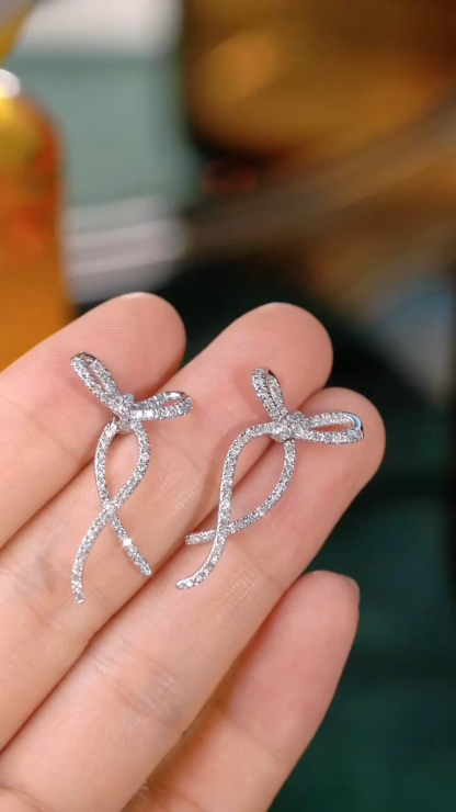 18k gold earrings with a bow design, featuring a natural diamond of 0.76carats