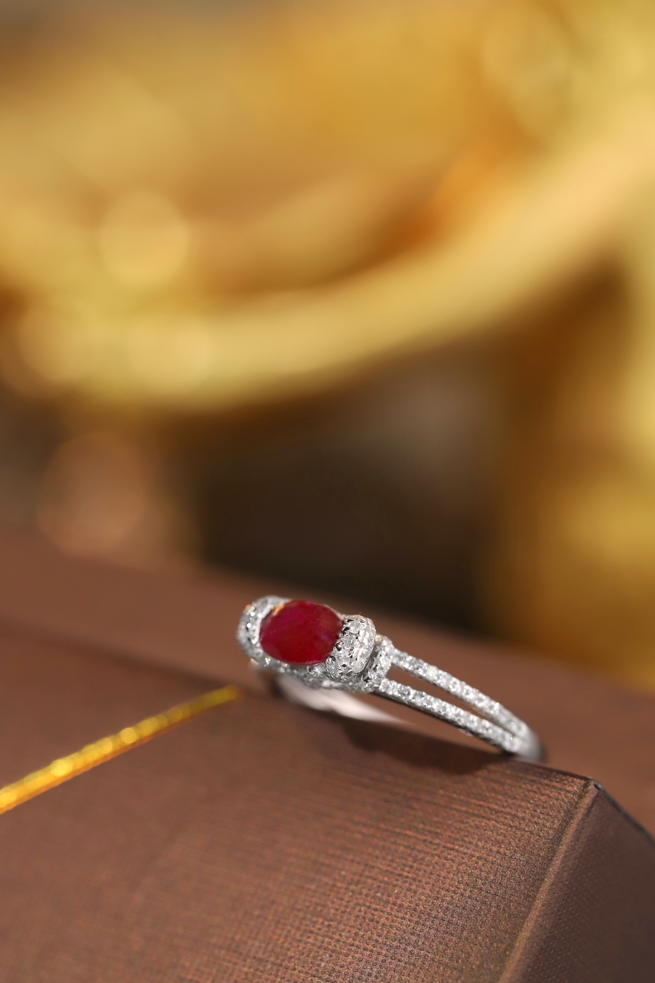 Set with 0.40 carats of natural diamonds and 0.60 carats of natural rubies, this 18K gold ring is oval in shape and is crafted using the four-prong setting technique.