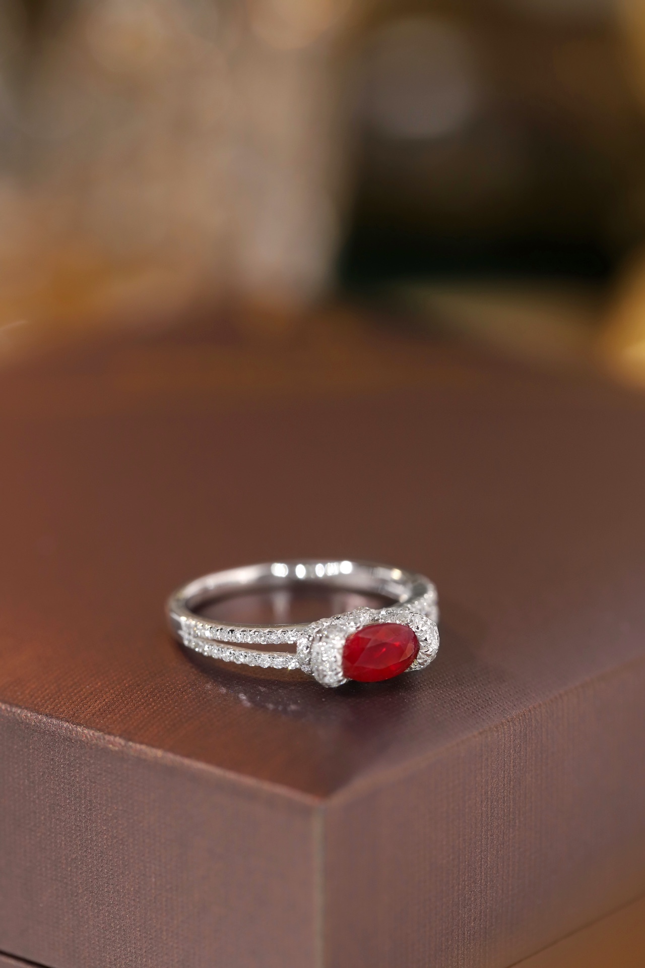 Set with 0.40 carats of natural diamonds and 0.60 carats of natural rubies, this 18K gold ring is oval in shape and is crafted using the four-prong setting technique.