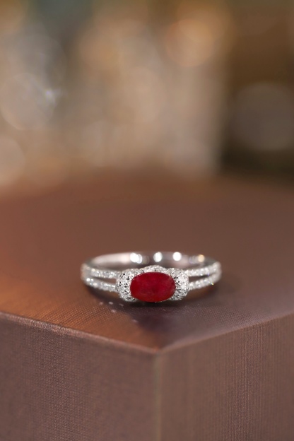 Set with 0.40 carats of natural diamonds and 0.60 carats of natural rubies, this 18K gold ring is oval in shape and is crafted using the four-prong setting technique.