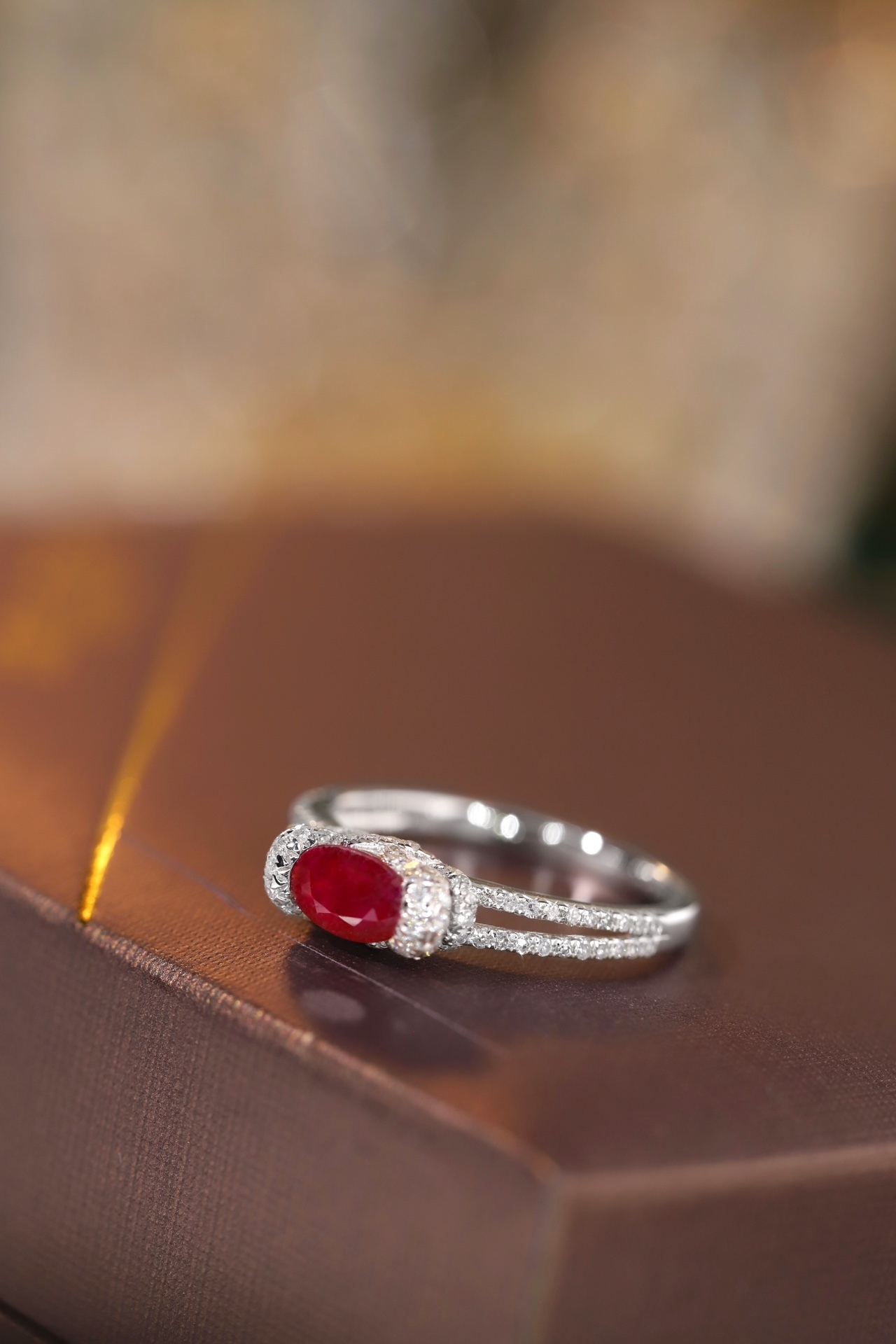 Set with 0.40 carats of natural diamonds and 0.60 carats of natural rubies, this 18K gold ring is oval in shape and is crafted using the four-prong setting technique.