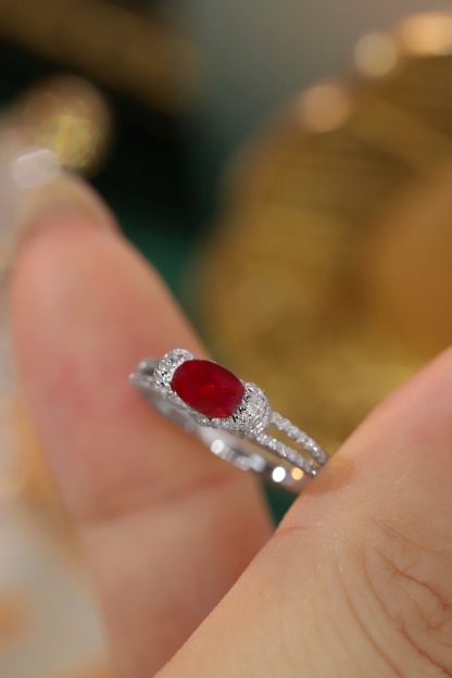 Set with 0.40 carats of natural diamonds and 0.60 carats of natural rubies, this 18K gold ring is oval in shape and is crafted using the four-prong setting technique.