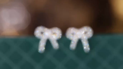 18k gold earrings with a bow design, featuring a natural diamond of 0.24 carats.