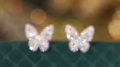 18-karat gold earrings in the shape of a butterfly, featuring a natural diamond of 0.64 carats set in a tapered baguette cut within a channel setting.