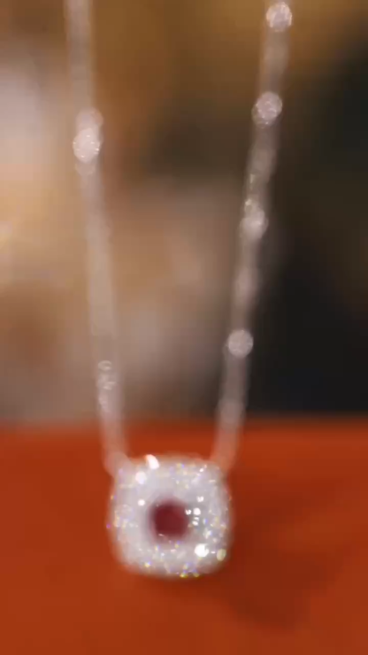 This 18K gold necklace is adorned with a 0.22-carat natural ruby, as well as tiny natural diamonds totaling 0.18 carats; the ruby in question has an oval shape.