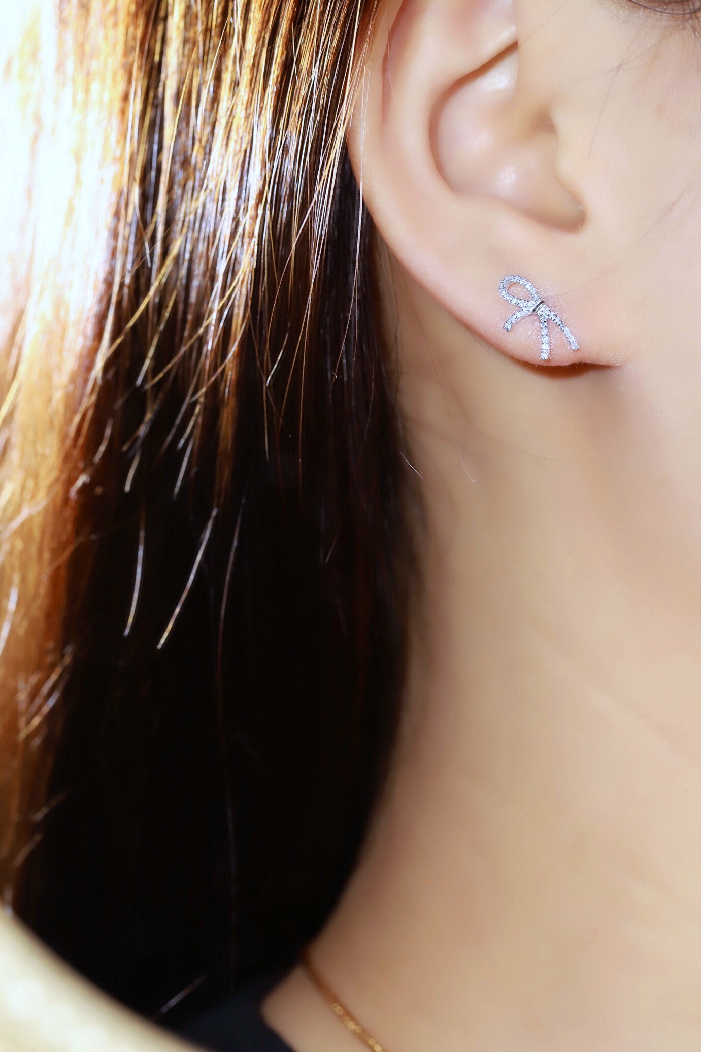 18k gold earrings with a bow design, featuring a natural diamond of 0.20carats.