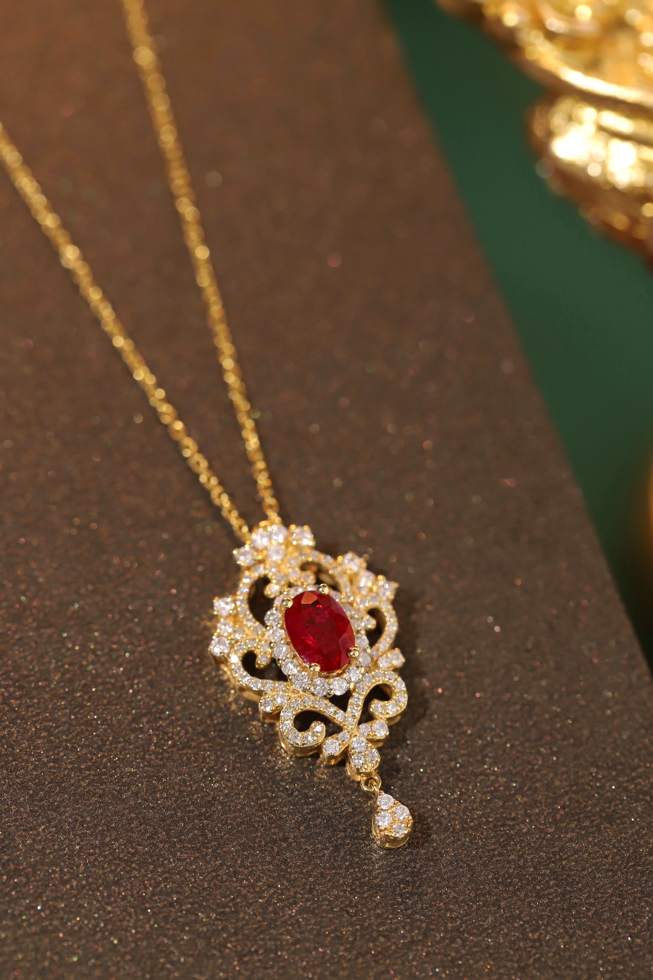 18K gold necklace with  design; the necklace is adorned with a 0.40-carat natural ruby and a 0.45-carat natural diamond, both set using the four-prong setting technique; the ruby has an oval shape.