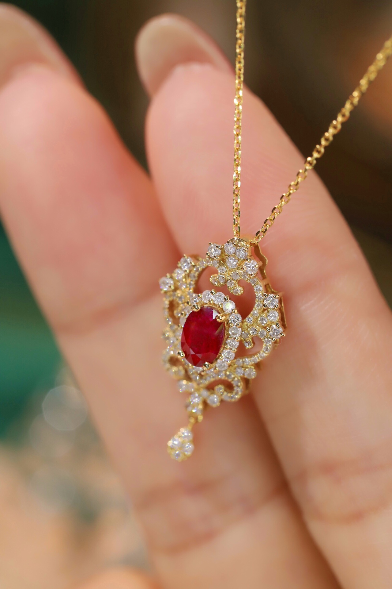 18K gold necklace with  design; the necklace is adorned with a 0.40-carat natural ruby and a 0.45-carat natural diamond, both set using the four-prong setting technique; the ruby has an oval shape.