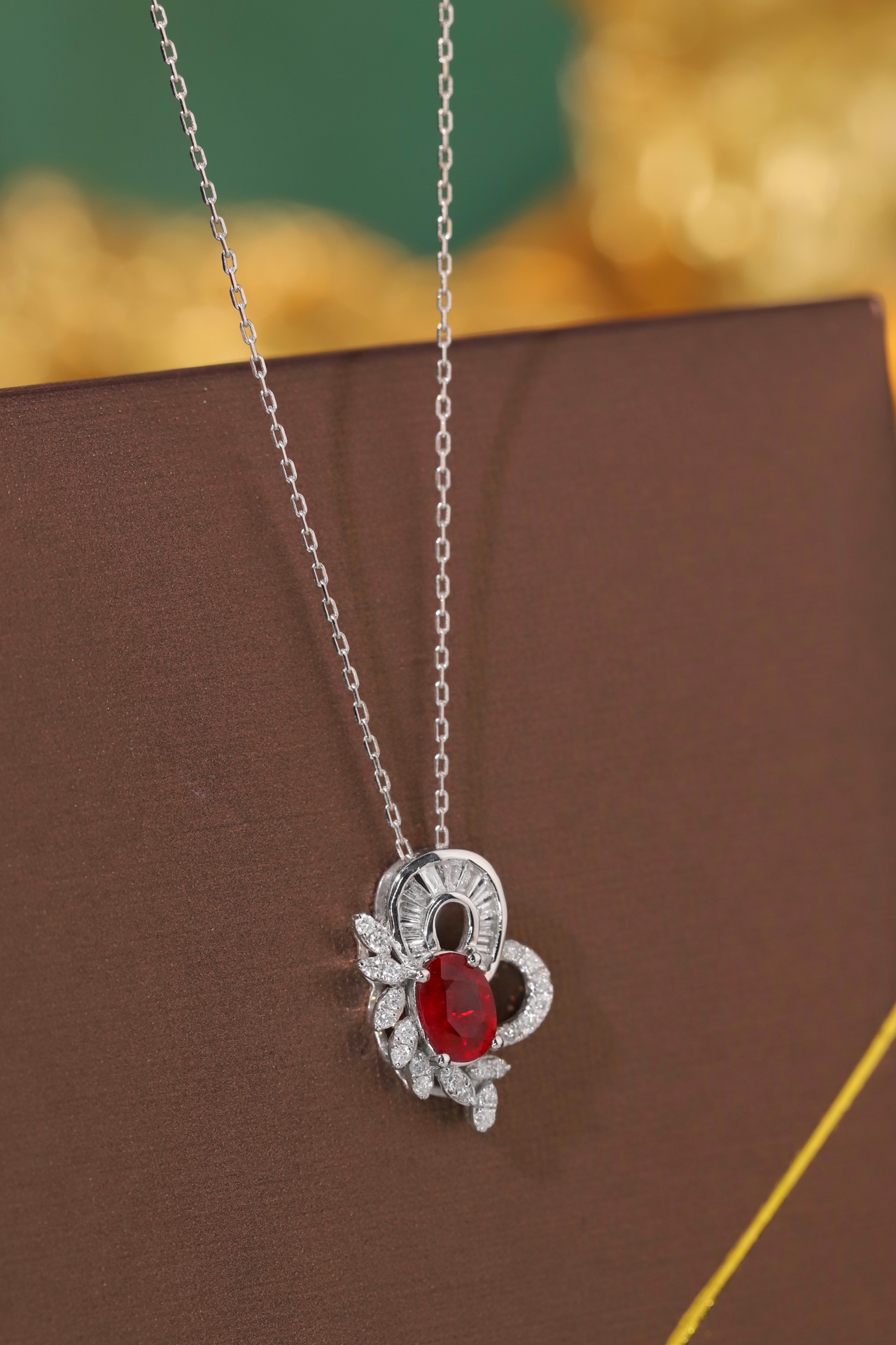 18K gold necklace  necklace is adorned with a 0.55-carat natural ruby and a 0.30-carat natural diamond; both stones are secured in place using a four-prong setting. The ruby has an oval shape, while the diamond is of a squ