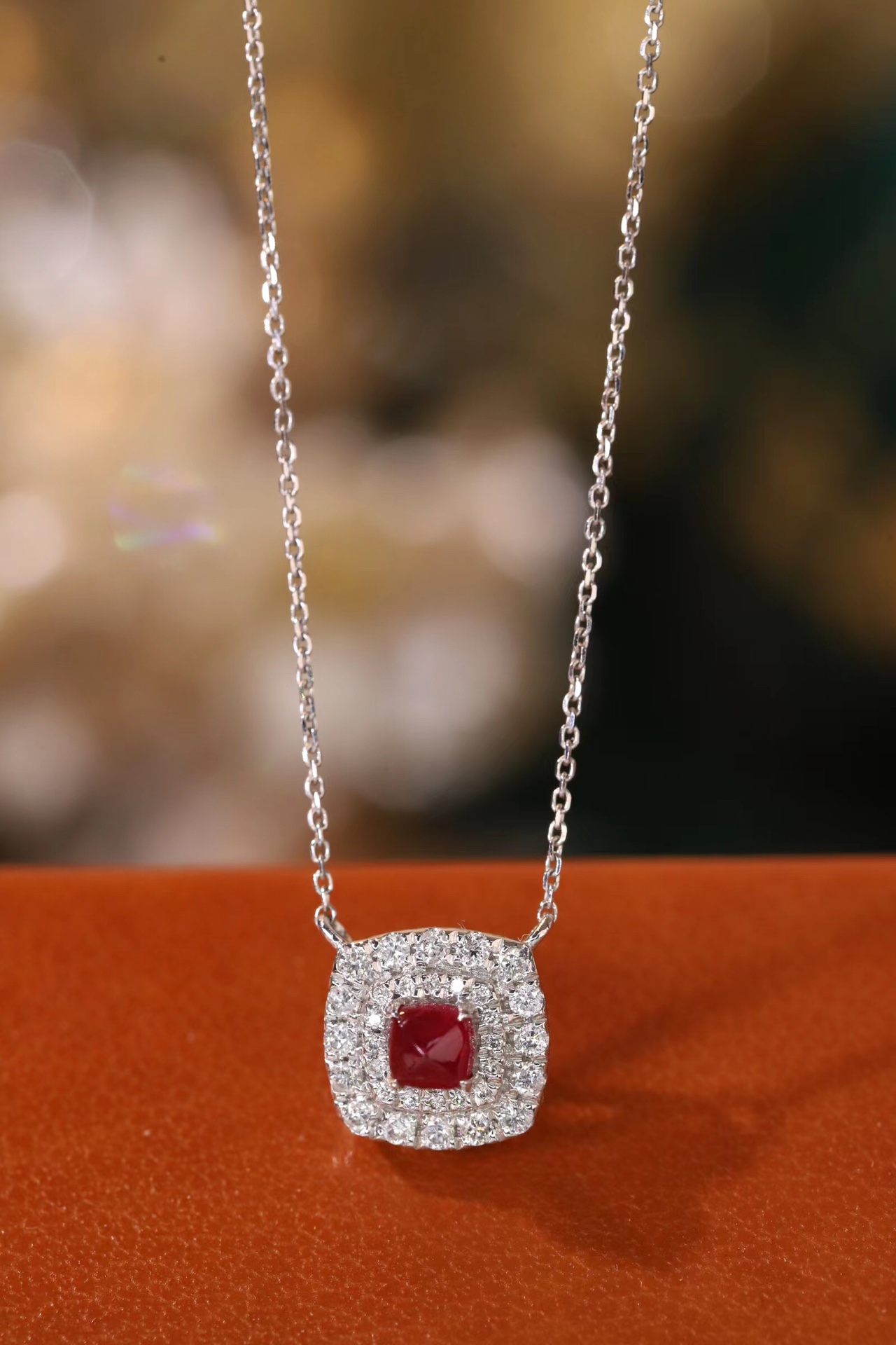 This 18K gold necklace is adorned with a 0.22-carat natural ruby, as well as tiny natural diamonds totaling 0.18 carats; the ruby in question has an oval shape.