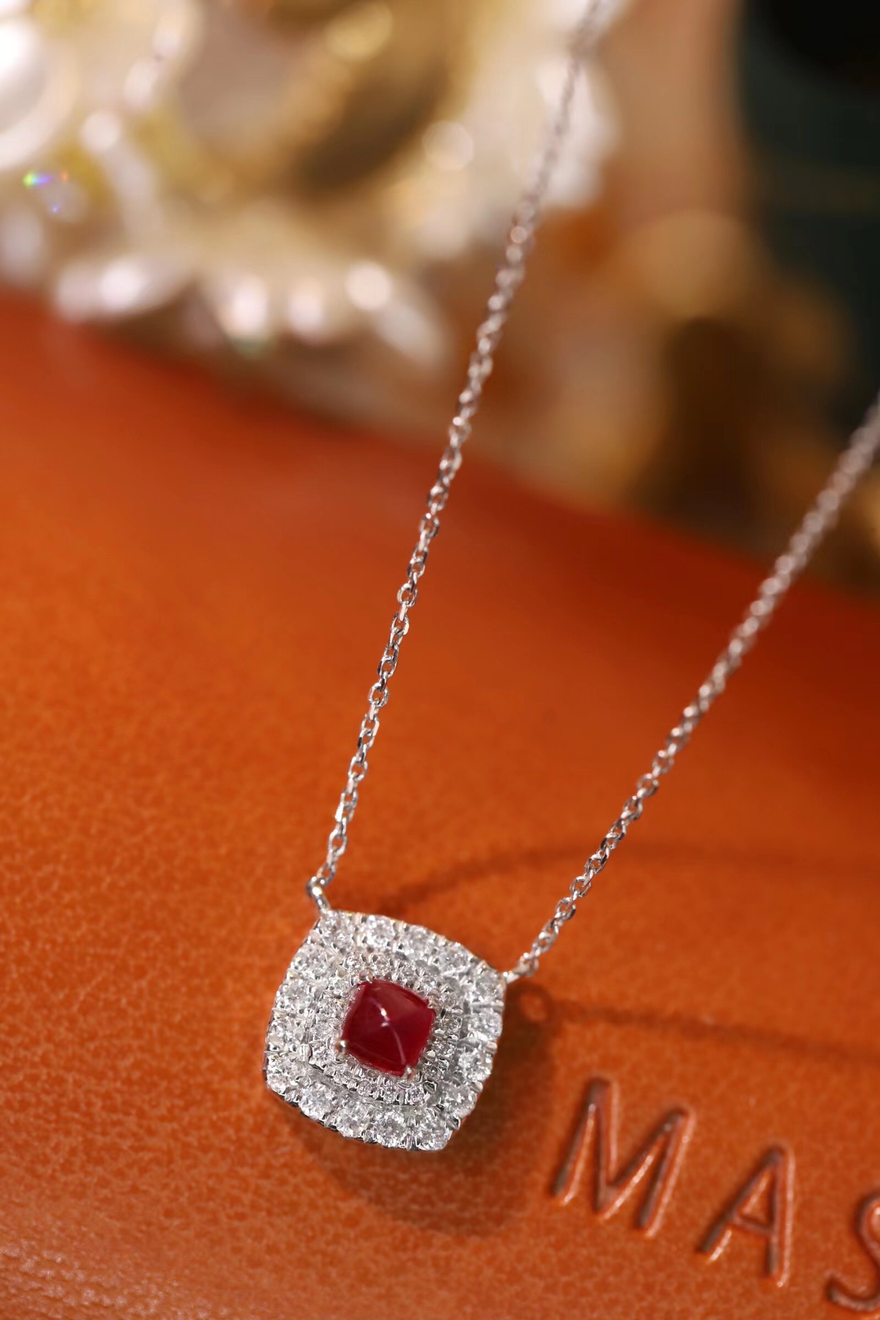 This 18K gold necklace is adorned with a 0.22-carat natural ruby, as well as tiny natural diamonds totaling 0.18 carats; the ruby in question has an oval shape.