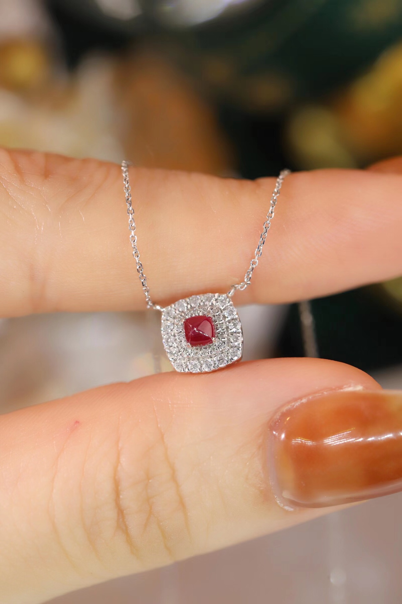 This 18K gold necklace is adorned with a 0.22-carat natural ruby, as well as tiny natural diamonds totaling 0.18 carats; the ruby in question has an oval shape.
