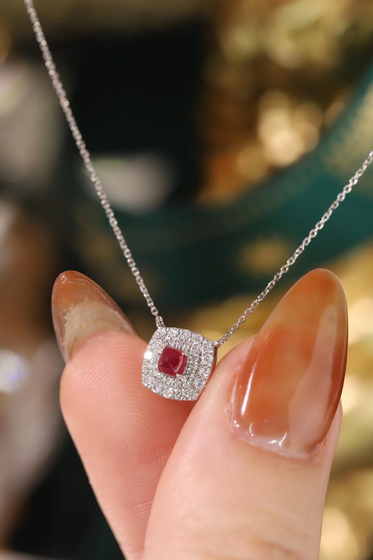 This 18K gold necklace is adorned with a 0.22-carat natural ruby, as well as tiny natural diamonds totaling 0.18 carats; the ruby in question has an oval shape.