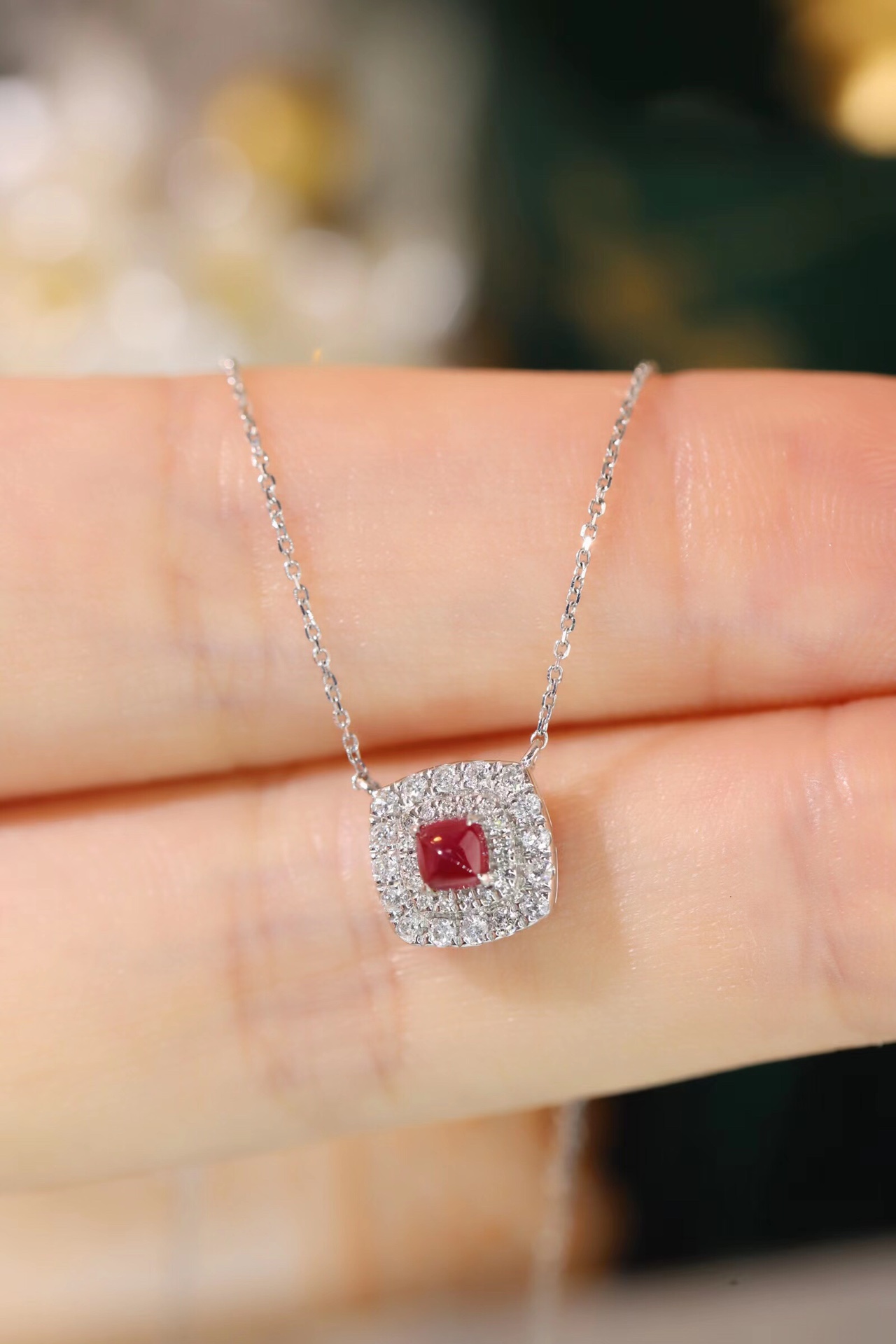 This 18K gold necklace is adorned with a 0.22-carat natural ruby, as well as tiny natural diamonds totaling 0.18 carats; the ruby in question has an oval shape.