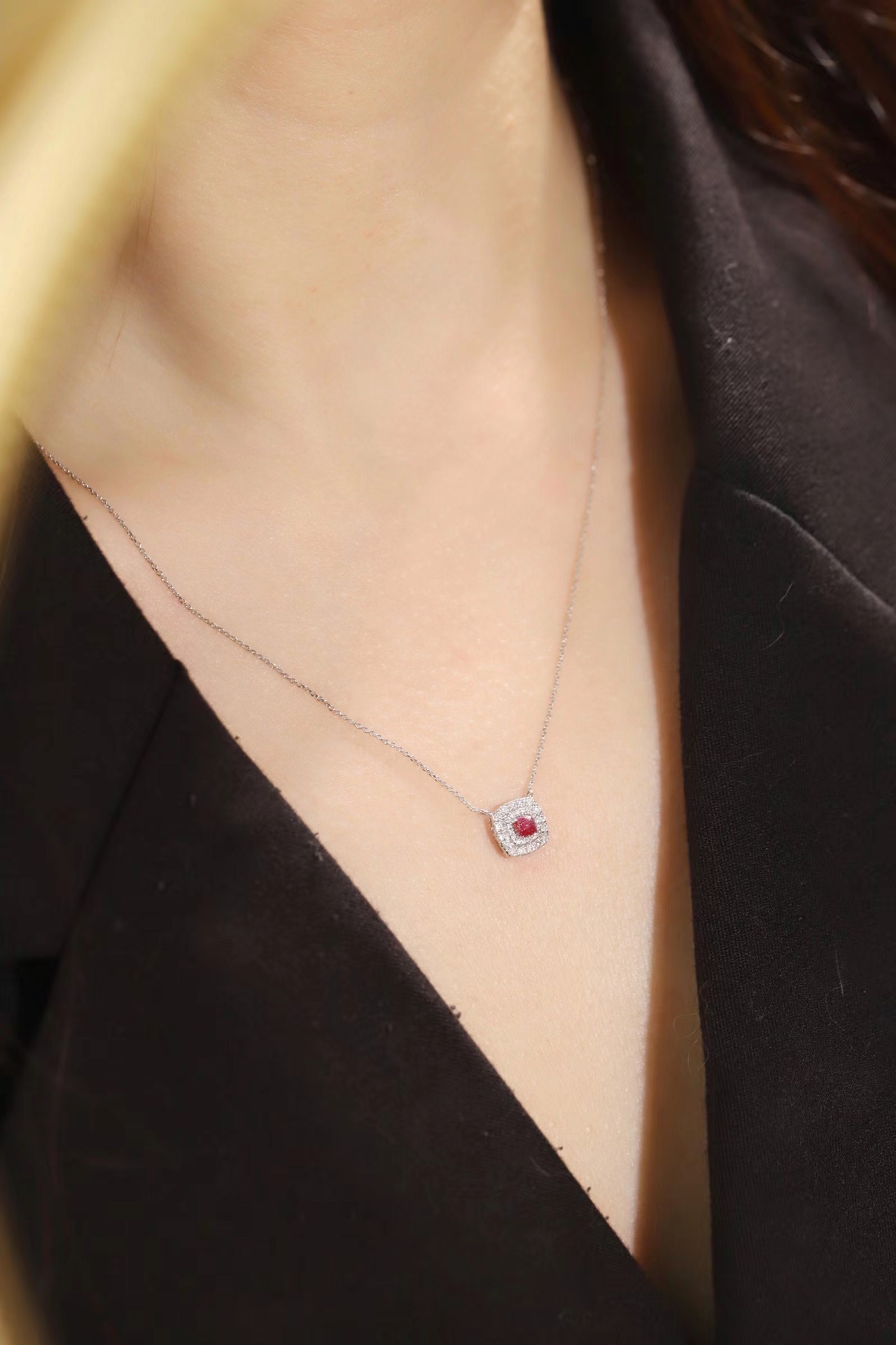 This 18K gold necklace is adorned with a 0.22-carat natural ruby, as well as tiny natural diamonds totaling 0.18 carats; the ruby in question has an oval shape.