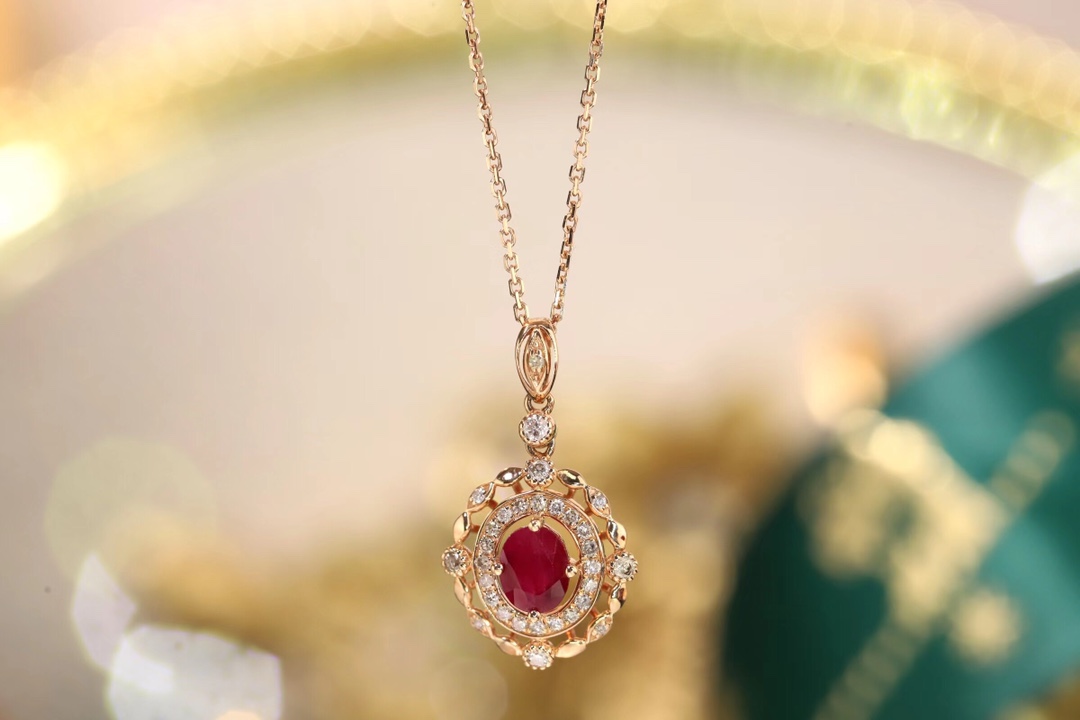 18k gold necklace set with an oval ruby of 0.45 carats, as well as additional stones of 0.15 carats each.