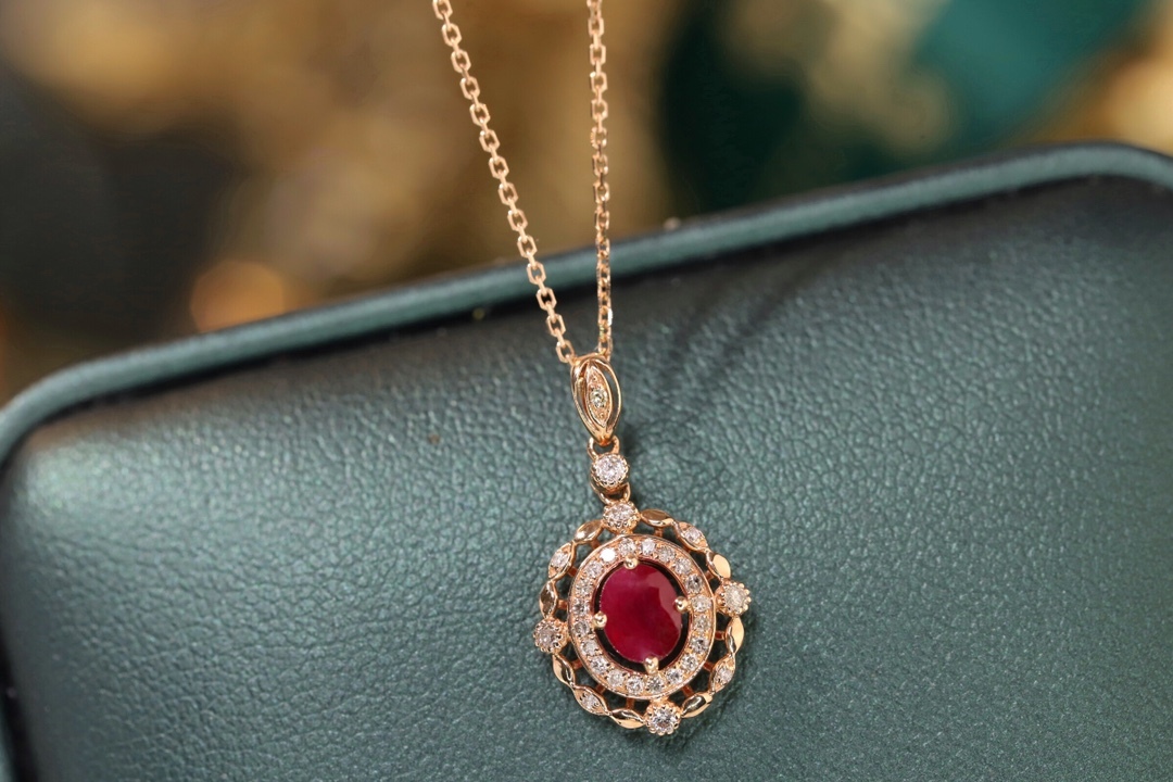 18k gold necklace set with an oval ruby of 0.45 carats, as well as additional stones of 0.15 carats each.