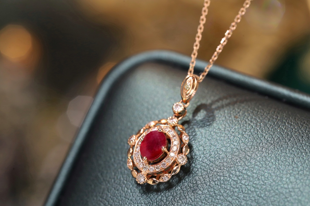 18k gold necklace set with an oval ruby of 0.45 carats, as well as additional stones of 0.15 carats each.