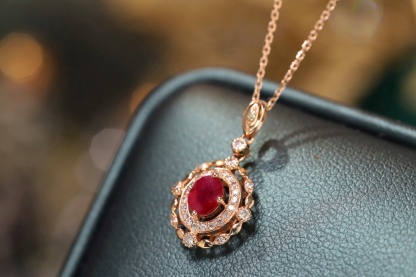 18k gold necklace set with an oval ruby of 0.45 carats, as well as additional stones of 0.15 carats each.