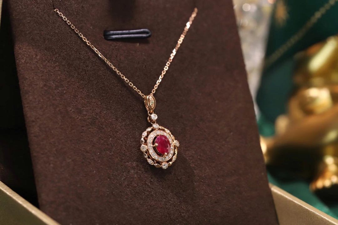 18k gold necklace set with an oval ruby of 0.45 carats, as well as additional stones of 0.15 carats each.
