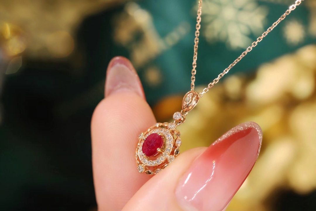 18k gold necklace set with an oval ruby of 0.45 carats, as well as additional stones of 0.15 carats each.