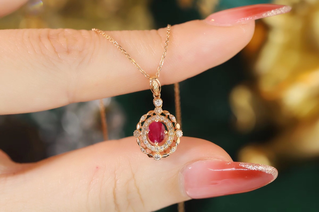 18k gold necklace set with an oval ruby of 0.45 carats, as well as additional stones of 0.15 carats each.