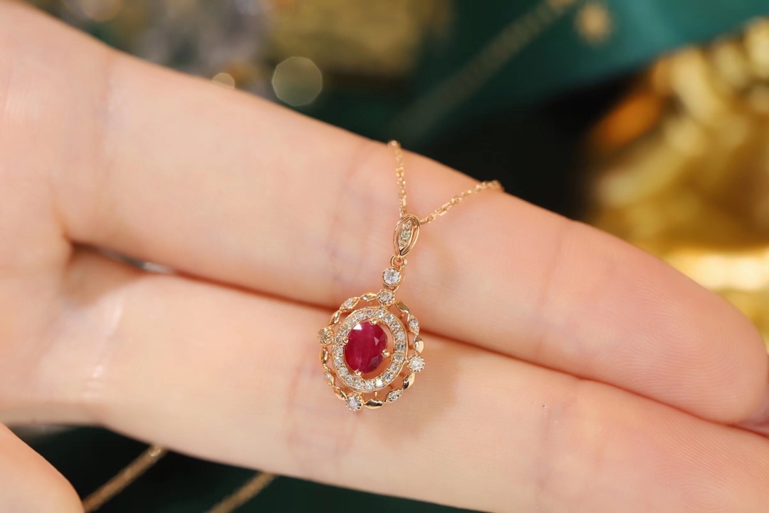 18k gold necklace set with an oval ruby of 0.45 carats, as well as additional stones of 0.15 carats each.