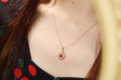 18k gold necklace set with an oval ruby of 0.45 carats, as well as additional stones of 0.15 carats each.