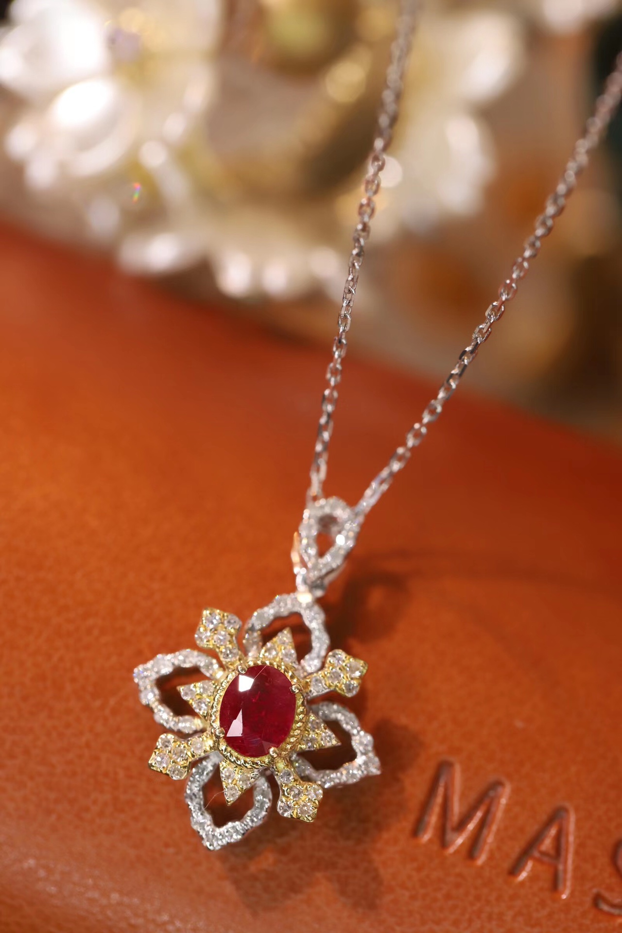 18k gold necklace set with an oval ruby of 0.38 carats, as well as additional stones of 0.22 carats each.