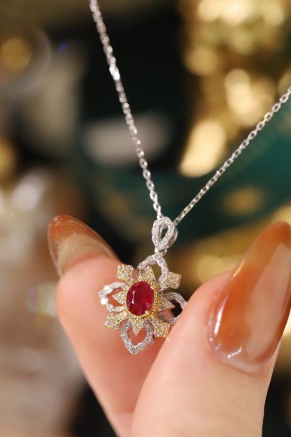 18k gold necklace set with an oval ruby of 0.38 carats, as well as additional stones of 0.22 carats each.