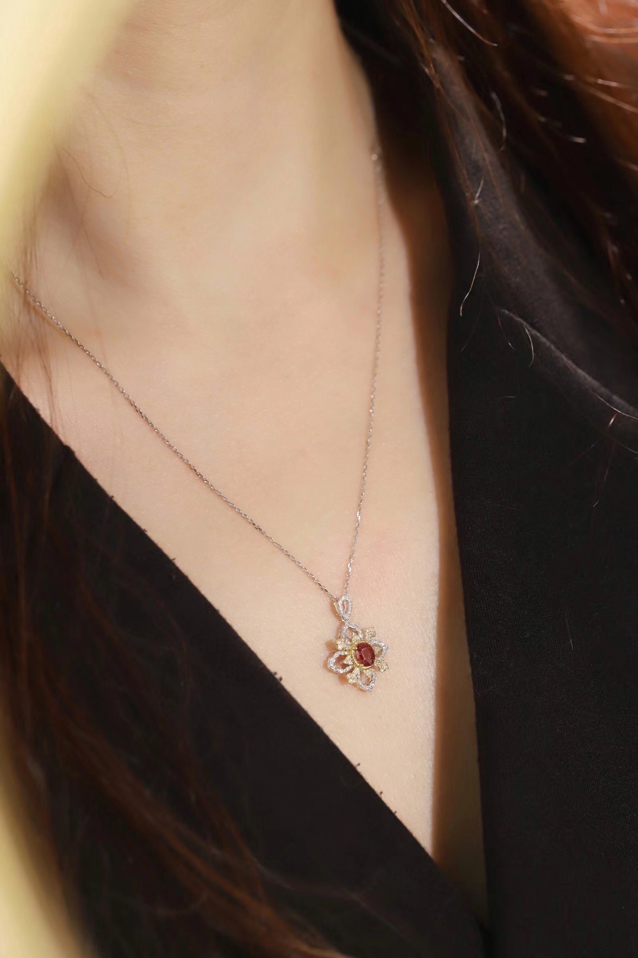 18k gold necklace set with an oval ruby of 0.38 carats, as well as additional stones of 0.22 carats each.