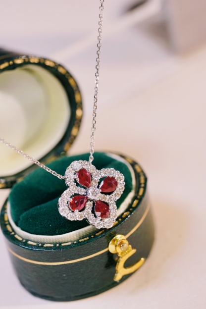 18k gold necklace in clover shape, with a droplet-shaped ruby of 0.70 carats and a natural diamond of also 0.70 carats.