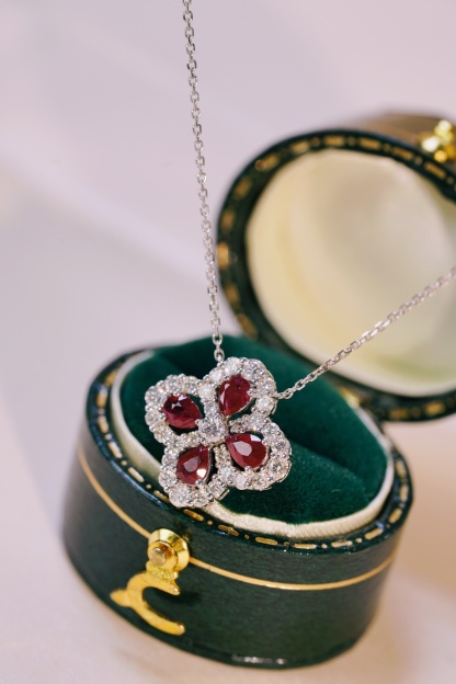 18k gold necklace in clover shape, with a droplet-shaped ruby of 0.70 carats and a natural diamond of also 0.70 carats.
