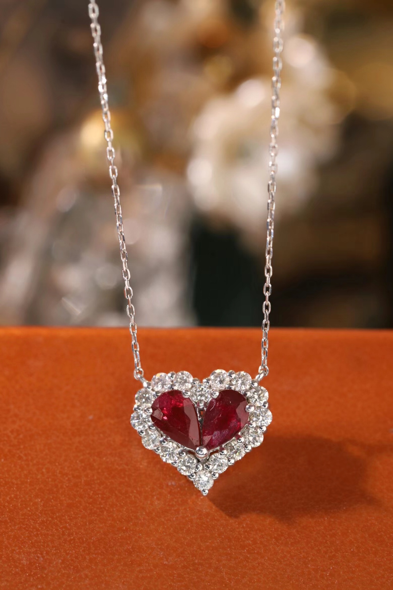 Heart-shaped 18k gold necklace set with a 0.92-carat ruby and a 0.45-carat diamond.