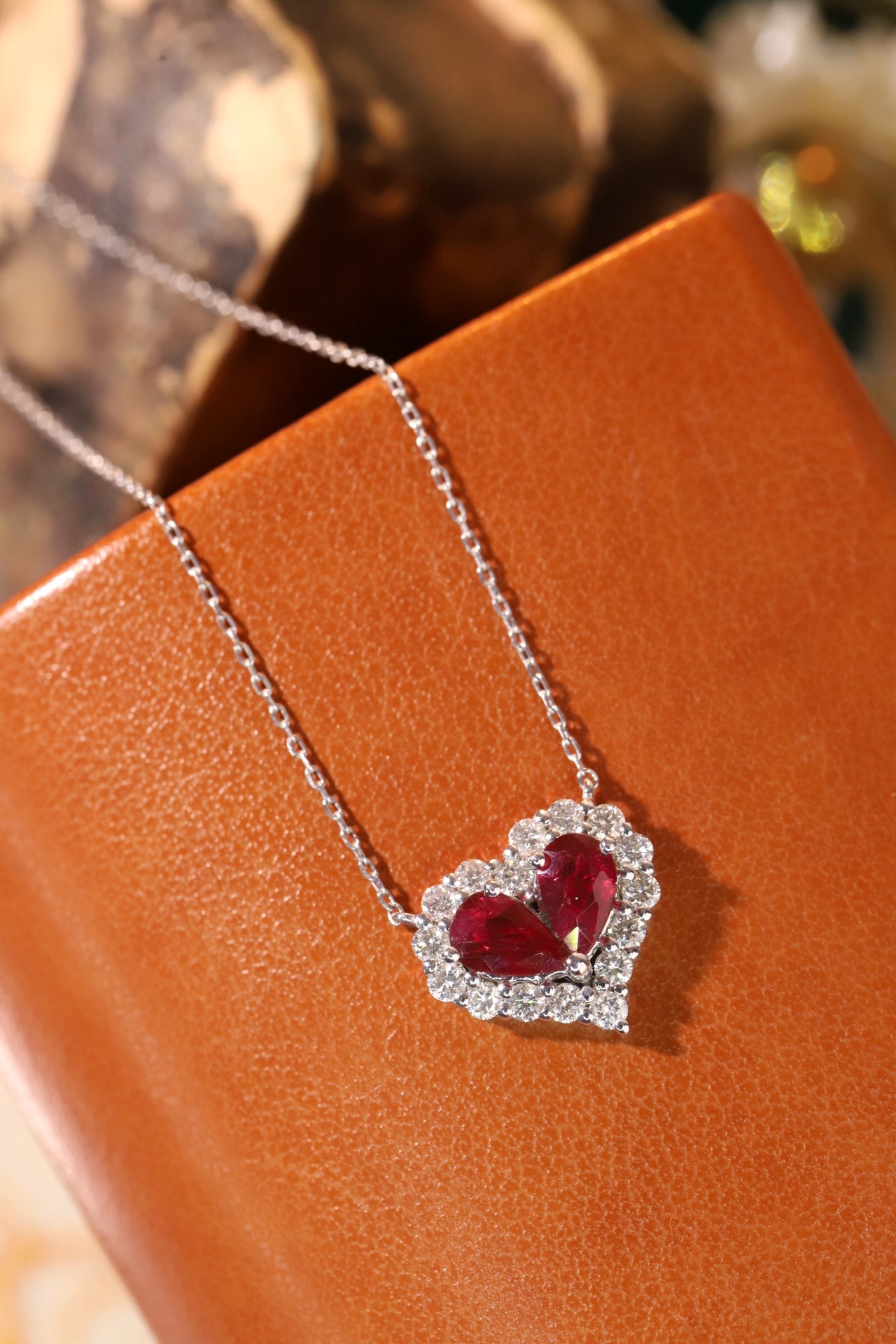 Heart-shaped 18k gold necklace set with a 0.92-carat ruby and a 0.45-carat diamond.