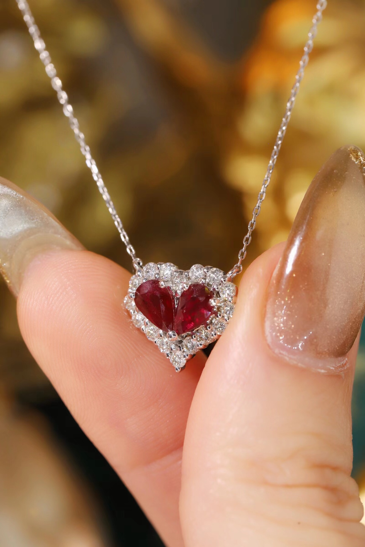 Heart-shaped 18k gold necklace set with a 0.92-carat ruby and a 0.45-carat diamond.