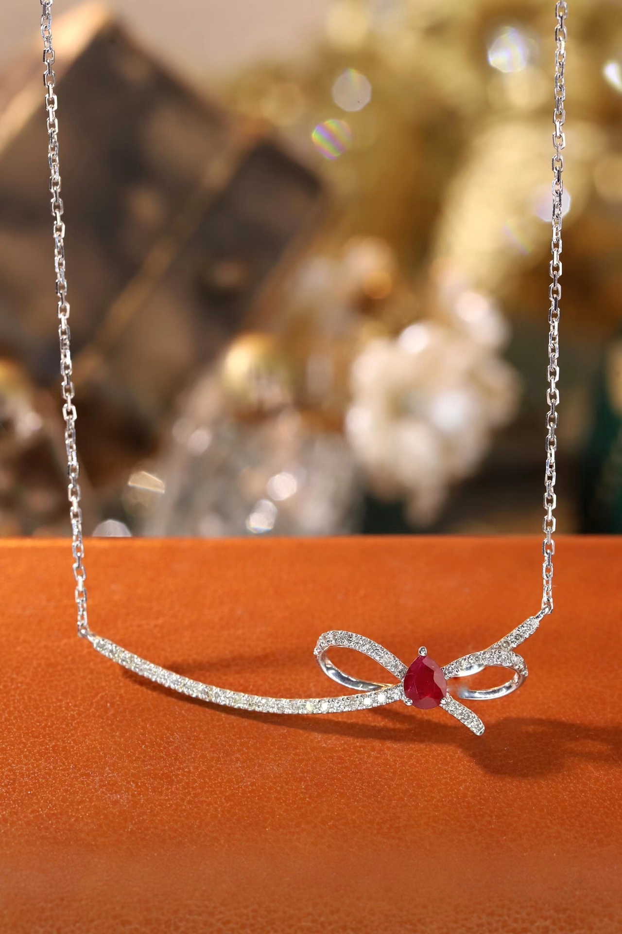 18k gold necklace with a bow design; the main diamond is 0.25 carats, and the side stone is also 0.25 carats.