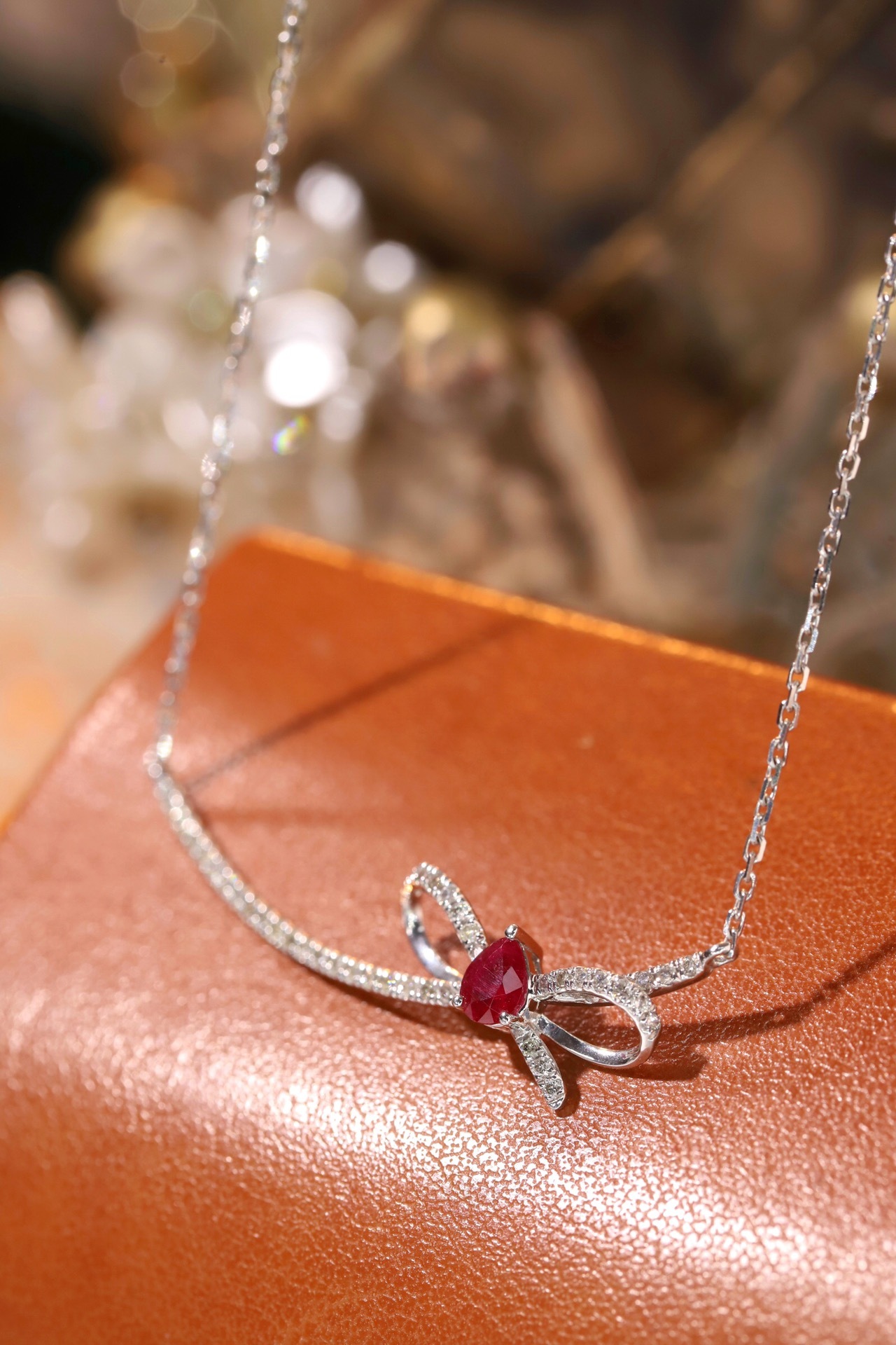 18k gold necklace with a bow design; the main diamond is 0.25 carats, and the side stone is also 0.25 carats.