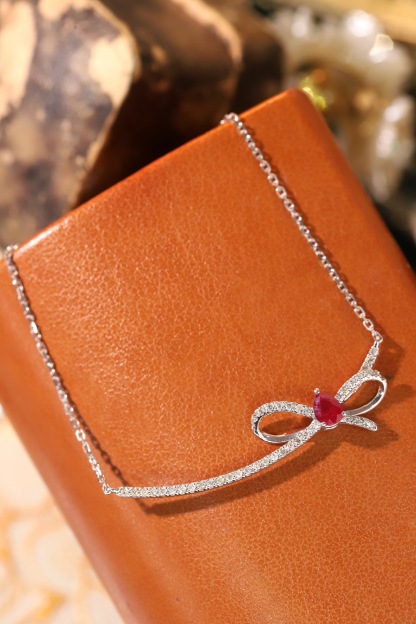 18k gold necklace with a bow design; the main diamond is 0.25 carats, and the side stone is also 0.25 carats.