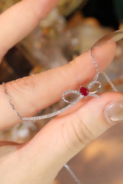 18k gold necklace with a bow design; the main diamond is 0.25 carats, and the side stone is also 0.25 carats.