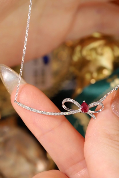 18k gold necklace with a bow design; the main diamond is 0.25 carats, and the side stone is also 0.25 carats.