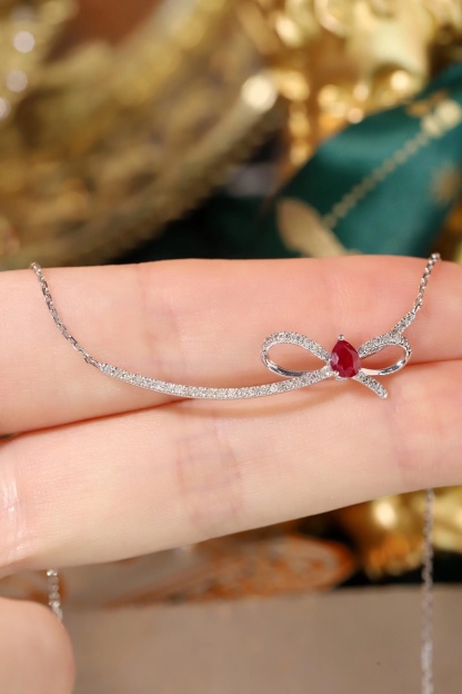 18k gold necklace with a bow design; the main diamond is 0.25 carats, and the side stone is also 0.25 carats.