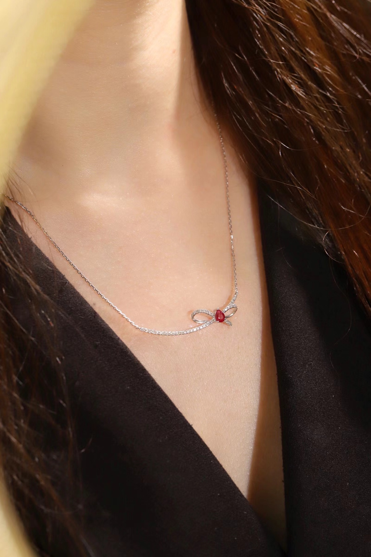 18k gold necklace with a bow design; the main diamond is 0.25 carats, and the side stone is also 0.25 carats.