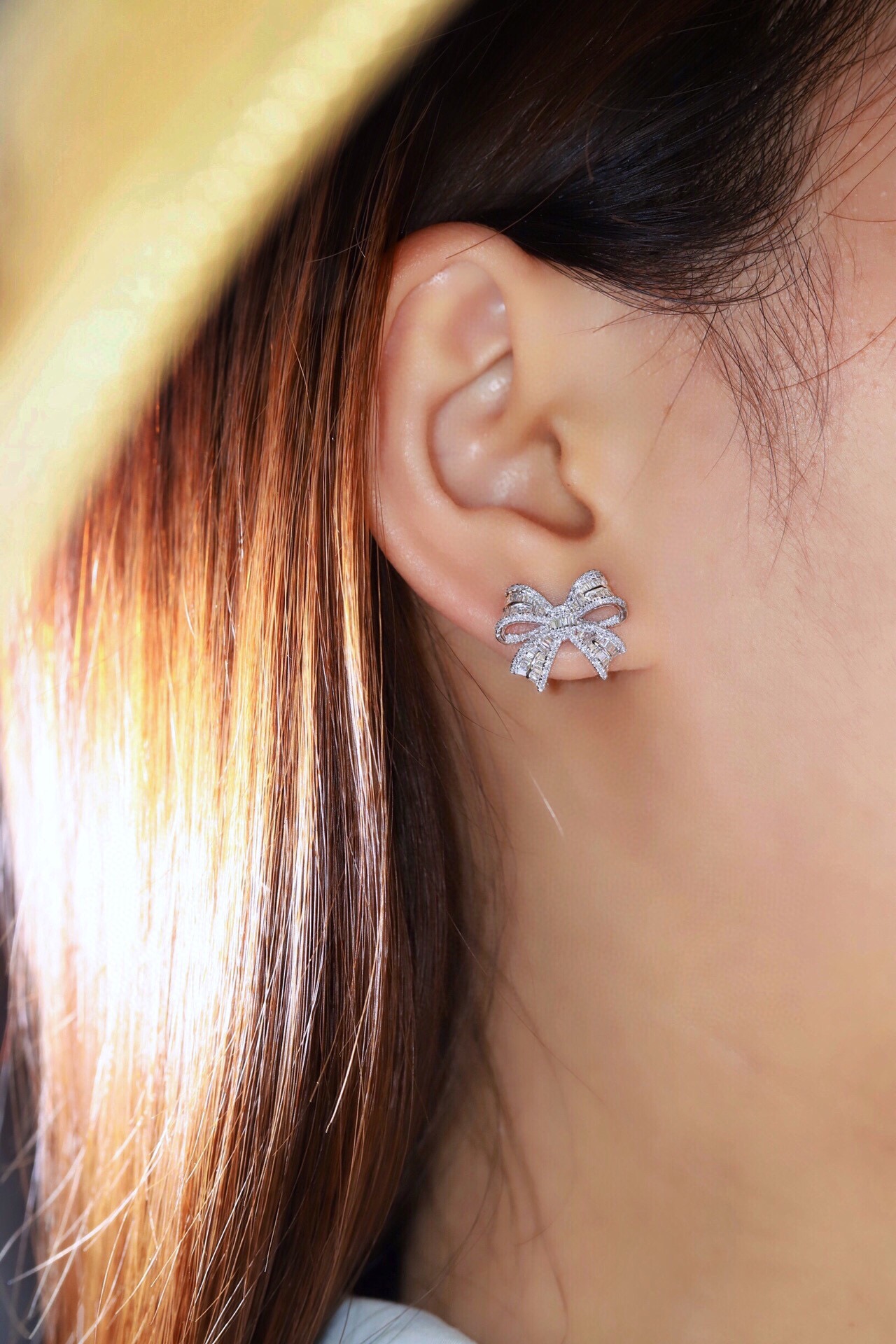 18-karat gold earrings in the shape of a butterfly, featuring a natural diamond of 1.00 carats set in a tapered baguette cut within a channel setting.