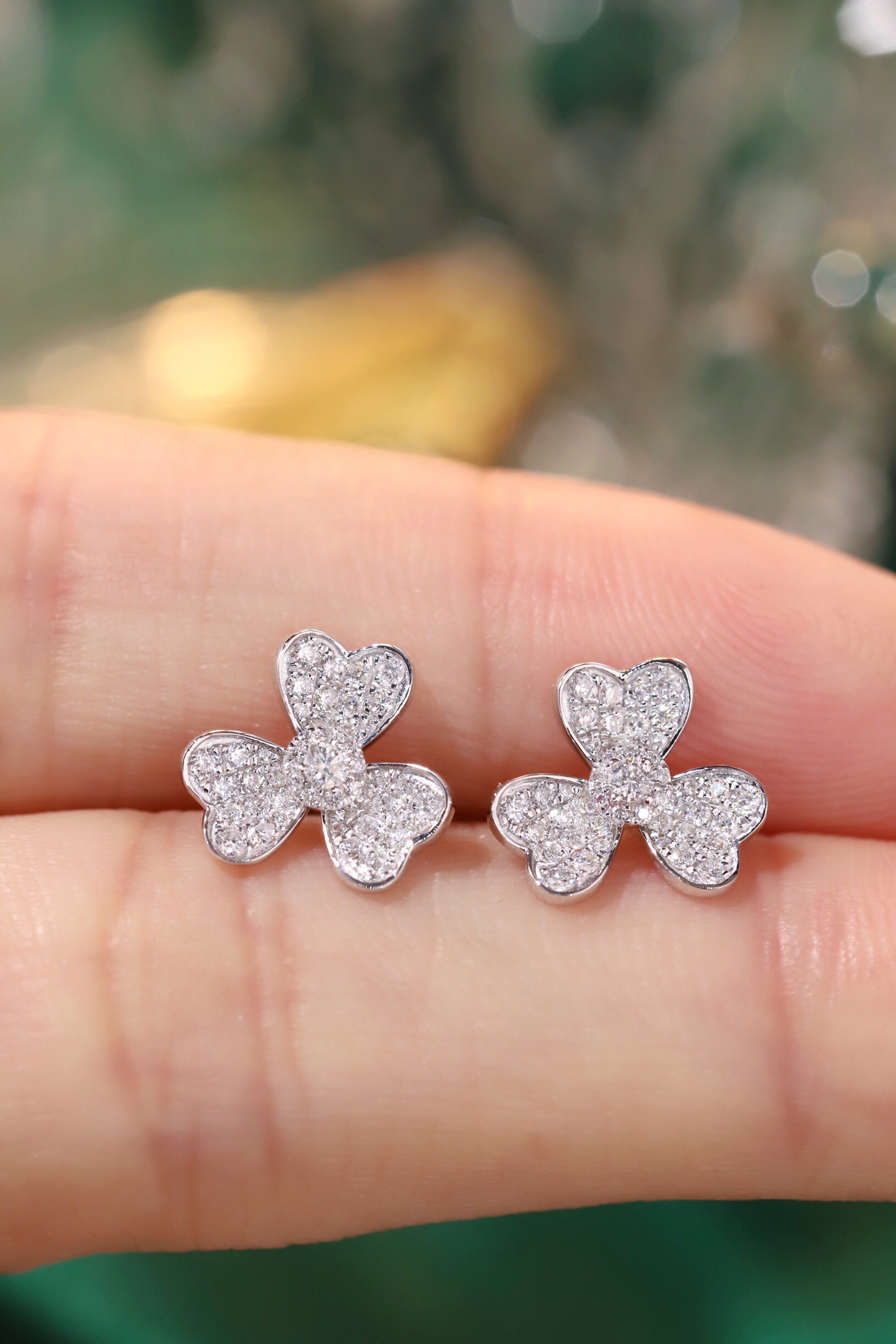 18k gold earrings in the shape of a four-leaf clover, set with a 0.44-carat natural diamond.