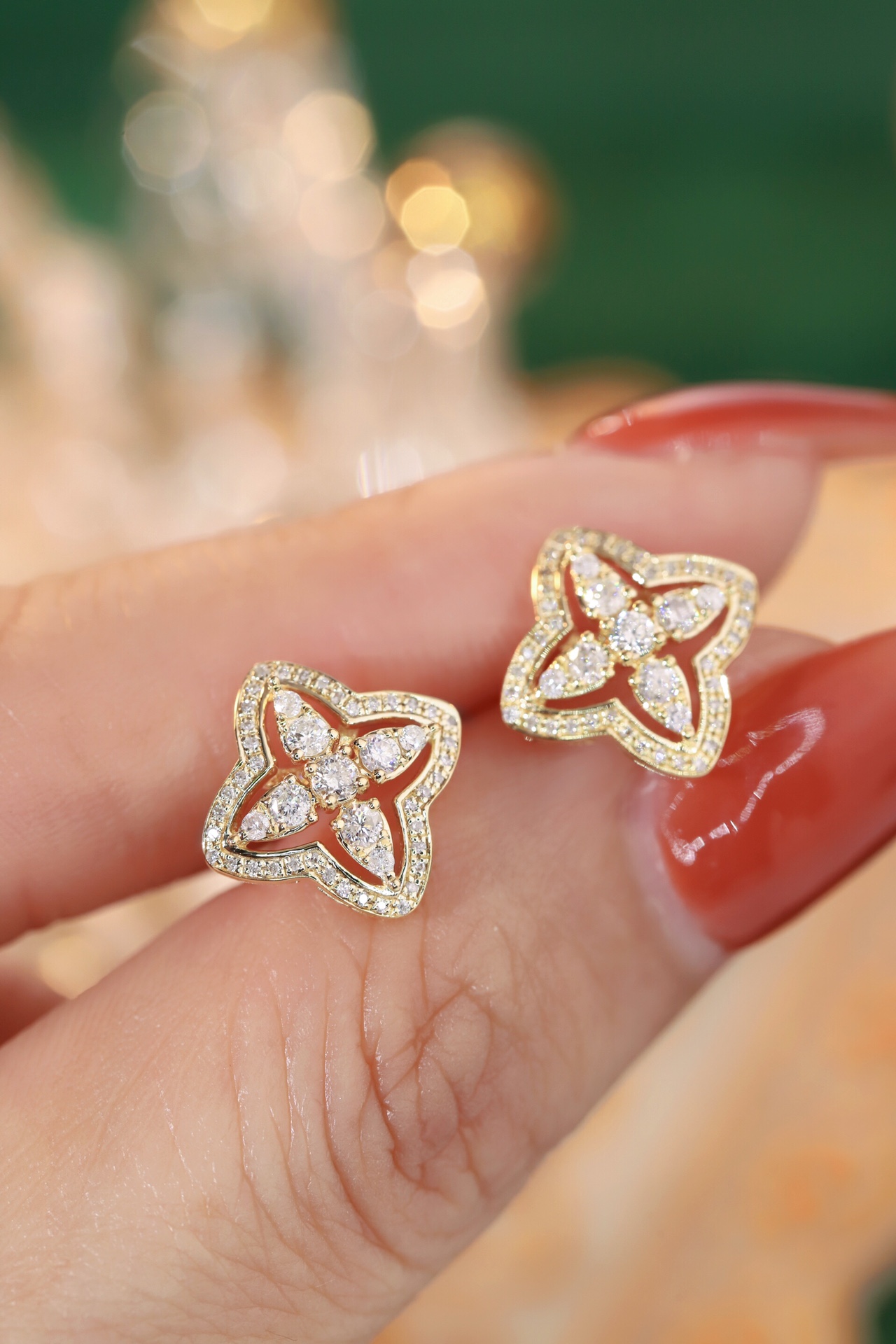 18k gold earrings in the shape of a four-leaf clover, set with a 0.42-carat natural diamond.